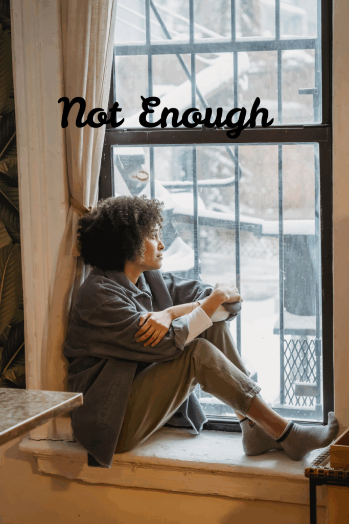 A young woman sits with her journal and Bible, reflecting on the lies she's believed and discovering God's truth.