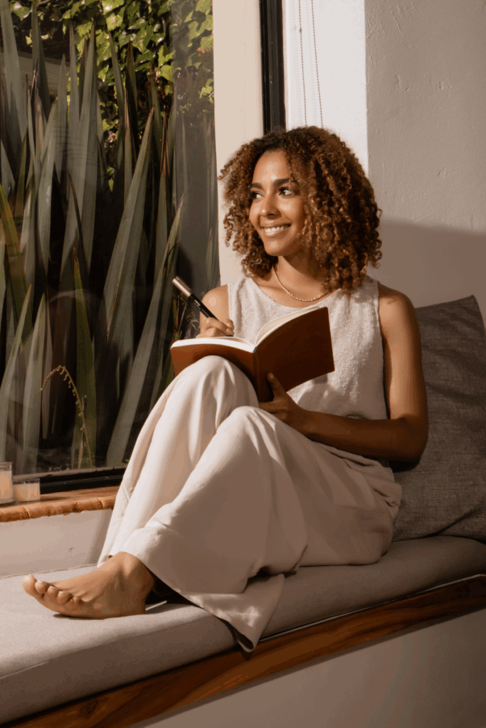 Close-up of woman writing in a journal during devotional time"